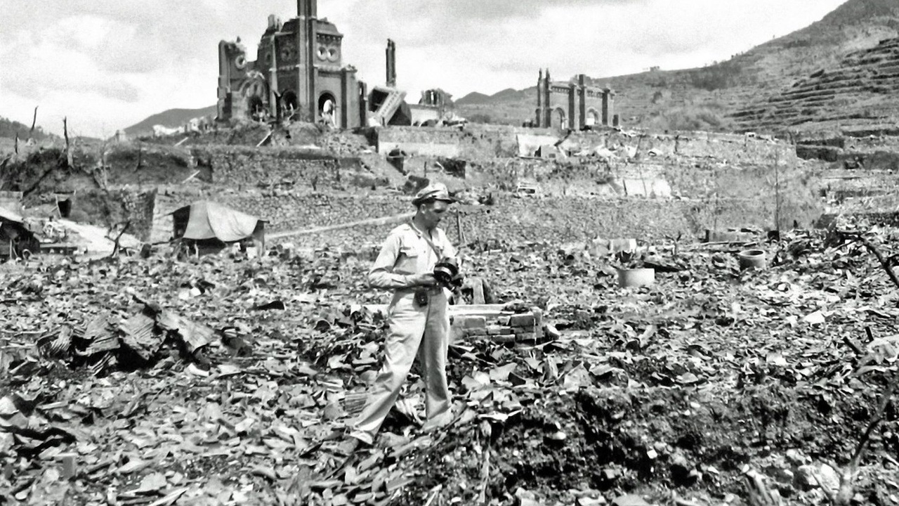 Bilde fra filmen Atomic cover up - mann med fotoapparat, stående i ruiner