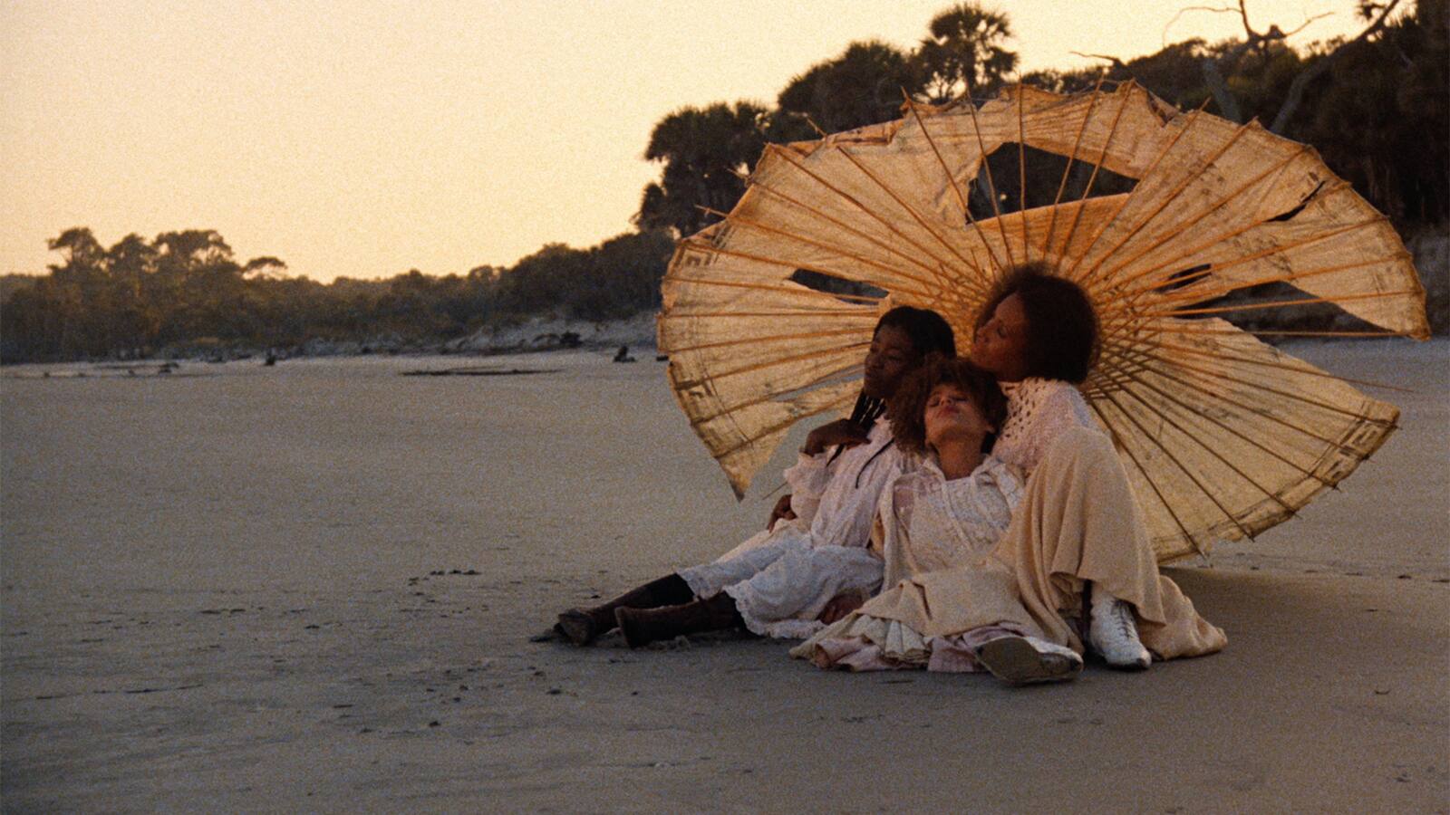 To kvinner under en paraply på en strand