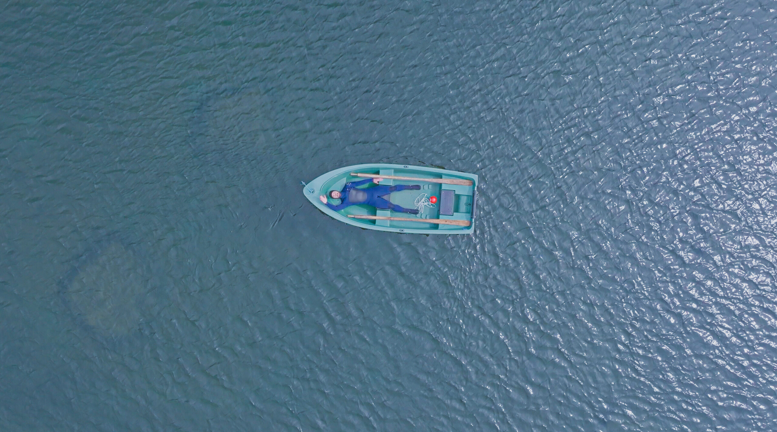 person i en båt på havet sett ovenfra